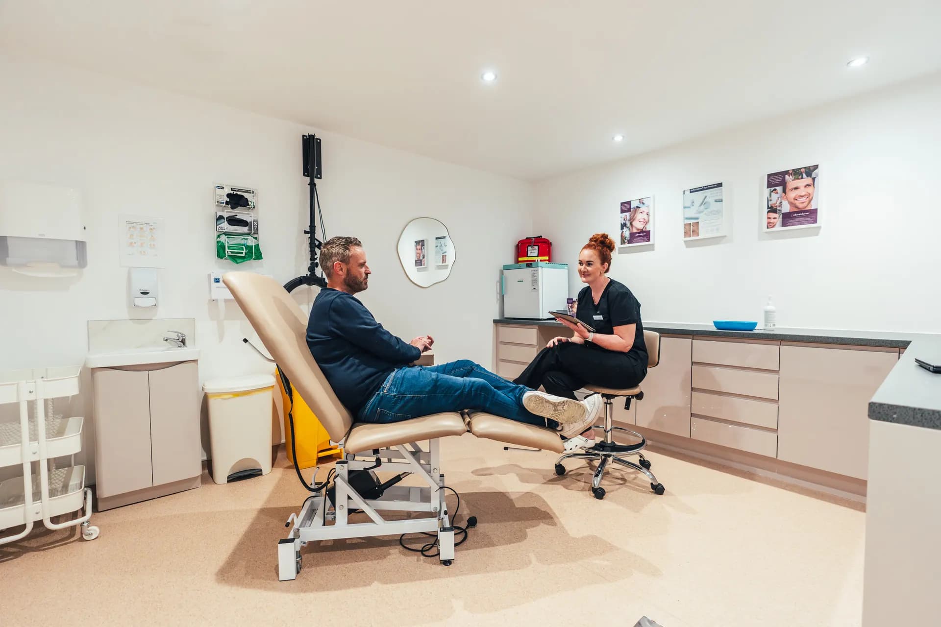 A patient talking with a practitioner in a treatment room