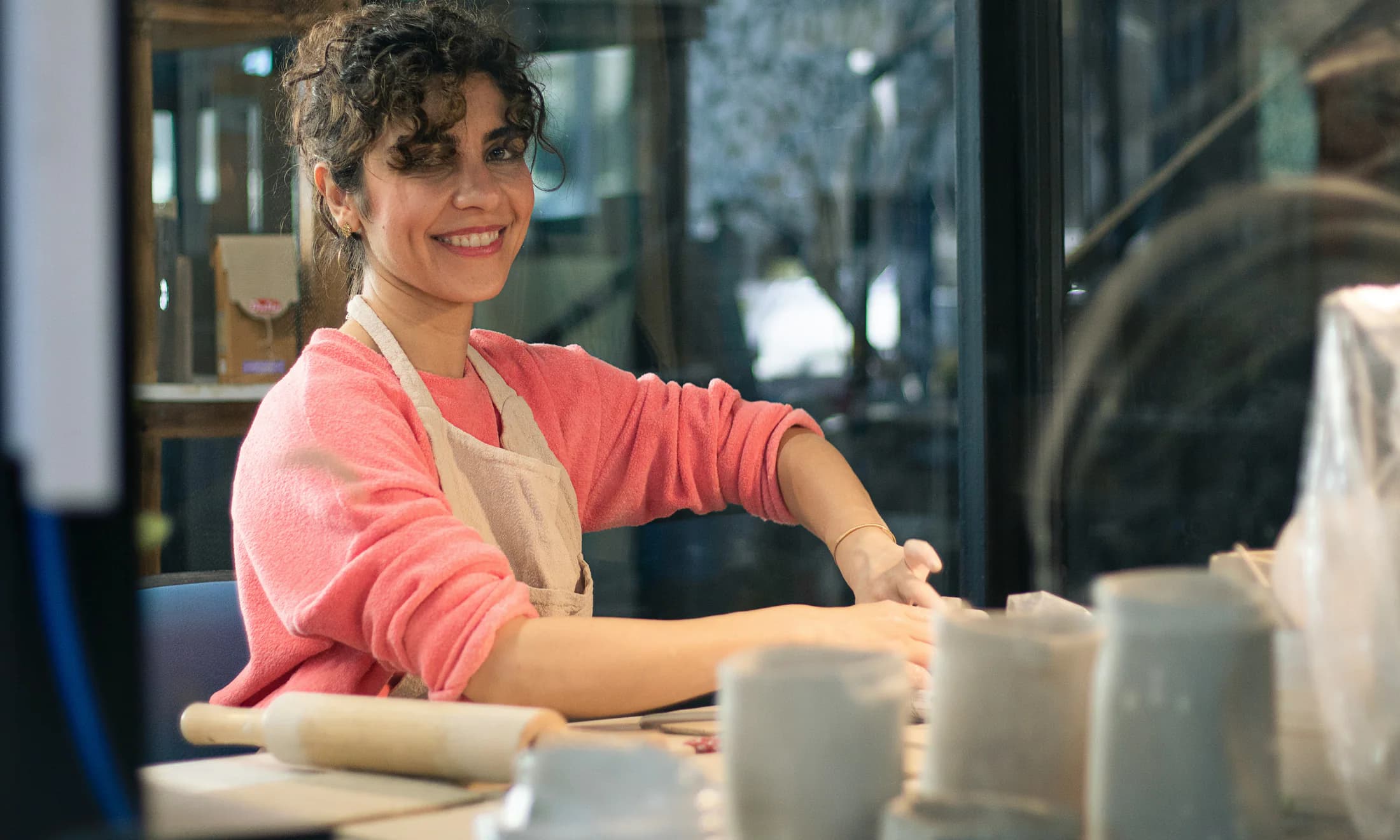 An independent studio owner working at a pottery table
